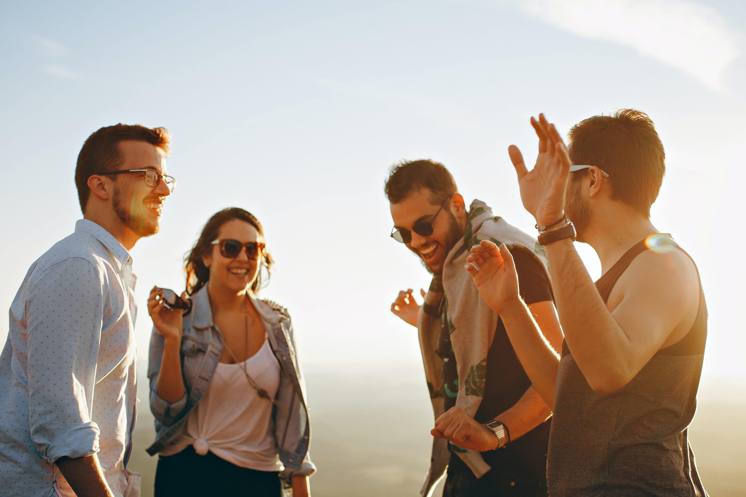 Friends laughing in the sun while discussing social media screening.